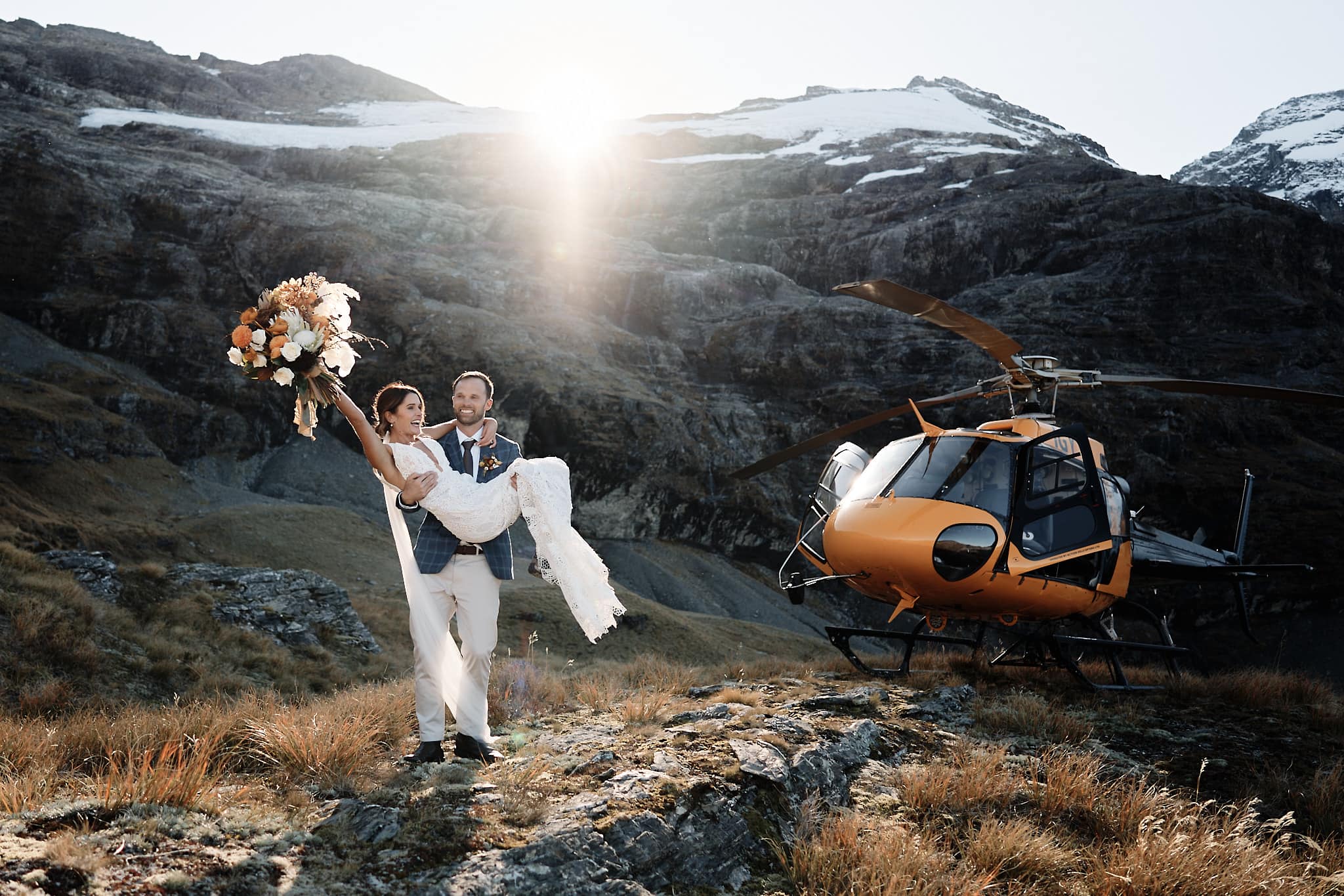 クイーンズタウン　ニュージーランド　ウェディング　前撮り　挙式　結婚式　フォトグラファー | クイーンズタウンの雄大なヘリコプターを背景に、特別な日を祝うカップル、新郎新婦。